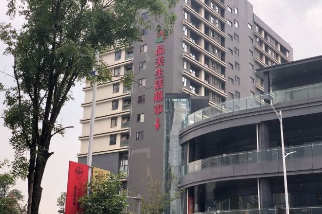 A multi-story building with a curved glass facade, likely a hotel or apartment complex.