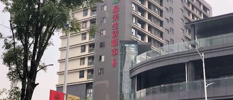 A multi-story building with a curved glass facade, likely a hotel or apartment complex.