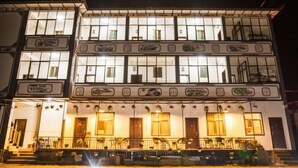 A multi-story building with illuminated windows and a balcony on the upper floor. - Dali Qihai Station (Dali City)
