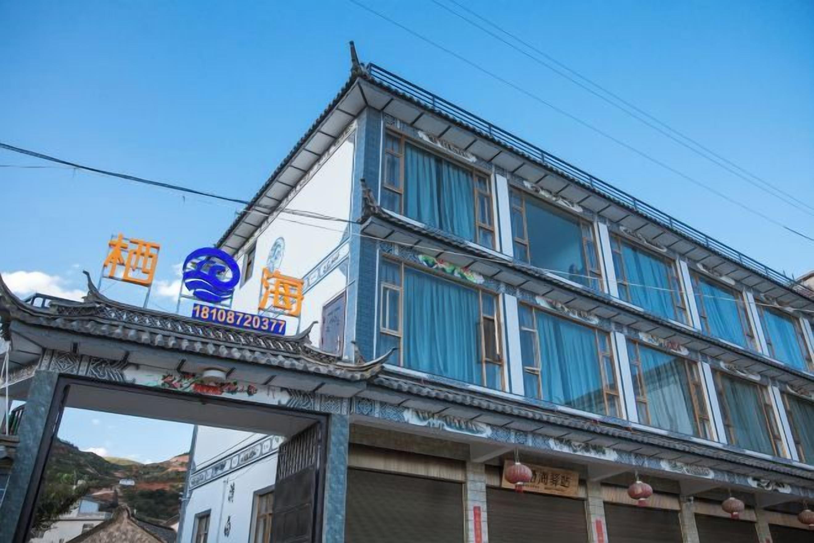 A traditional building with a blue facade and a sign with Chinese characters.
