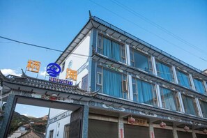 A traditional building with a blue facade and a sign with Chinese characters.
