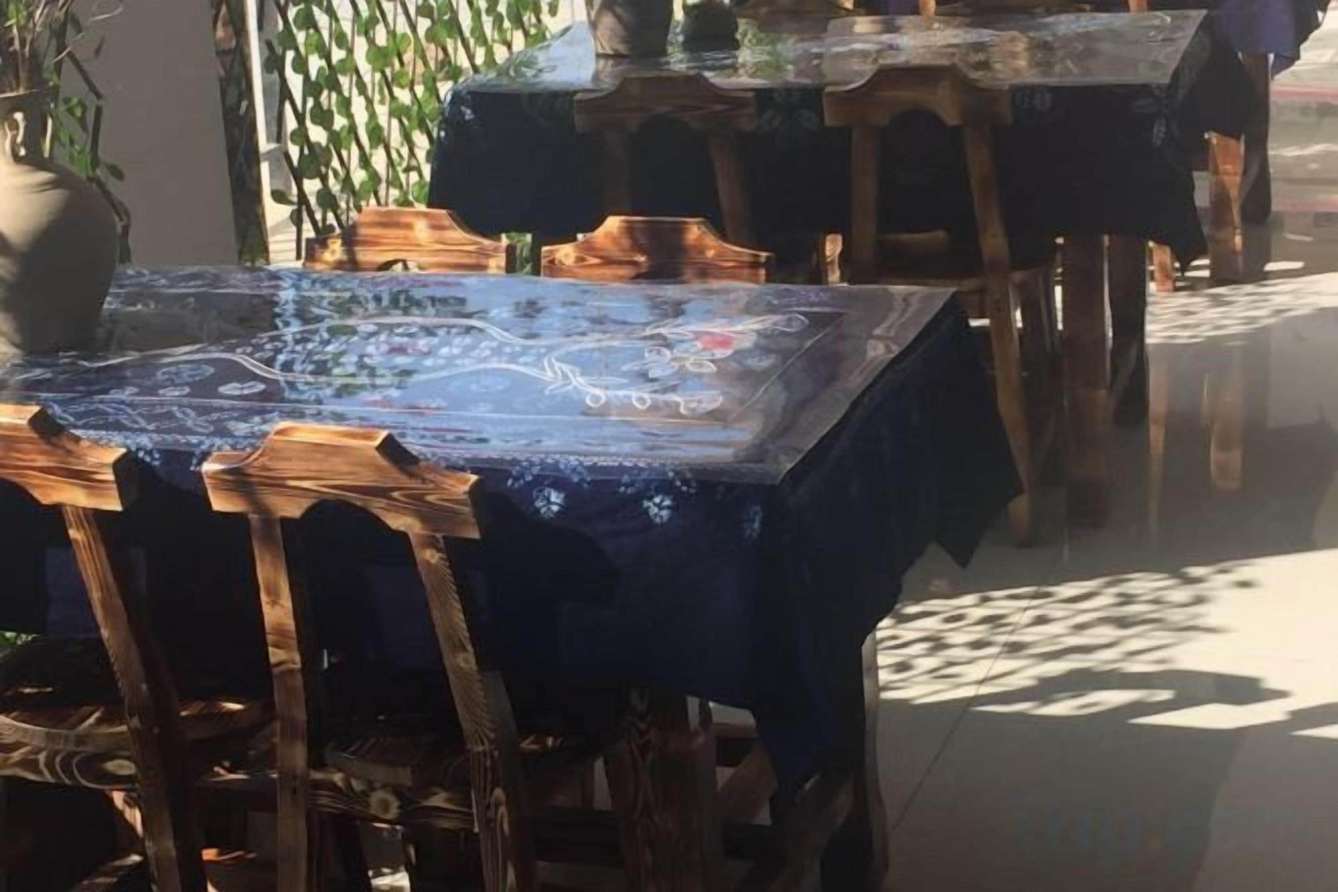 Un comedor con mesas cubiertas de manteles azules y sillas de madera.