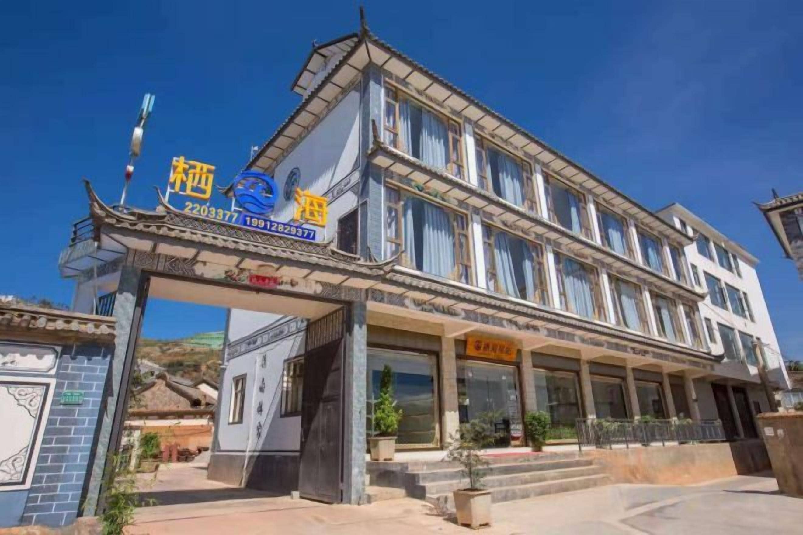 A hotel with a traditional architectural style, featuring a prominent entrance with a covered walkway and signage.