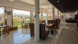 A spacious lobby with a high ceiling, large windows, and a mix of seating areas including tables and sofas. - Dali Qihai Station (Dali City)