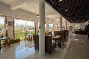 A spacious lobby with a high ceiling, large windows, and a mix of seating areas including tables and sofas. - Dali Qihai Station (Dali City)