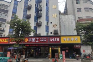 Un edificio con varios comercios en la planta baja, incluyendo una tienda Wallace, una casa de té y una tienda de ropa.