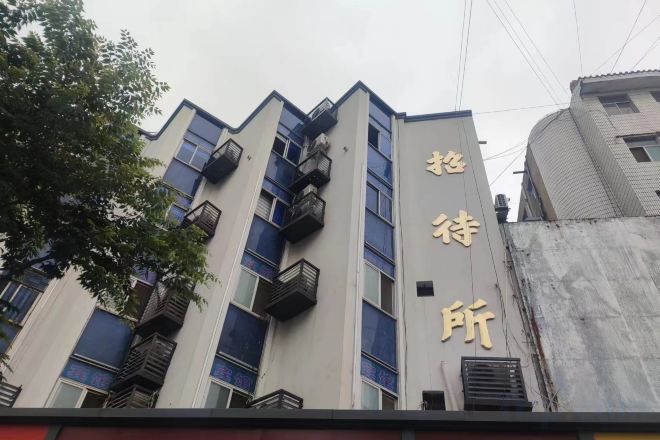 A building with multiple floors, balconies, and a sign with Chinese characters.