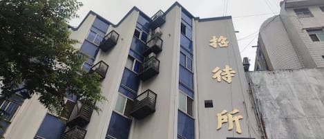 A building with multiple floors, balconies, and a sign with Chinese characters.