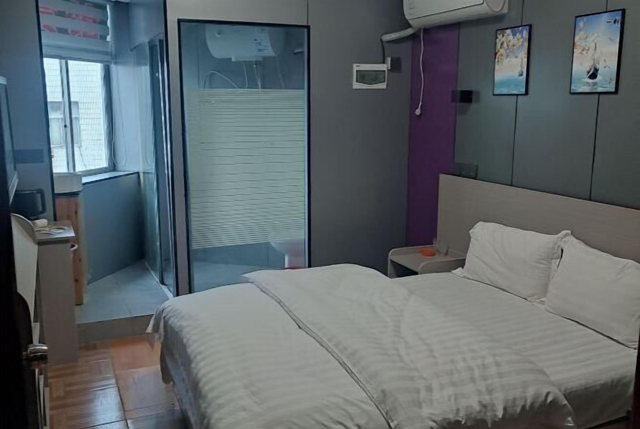 Una camera da letto con un letto, un comodino, una finestra e una porta che dà su un balcone.