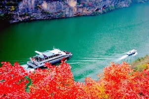 A boat on a river surrounded by autumn foliage.