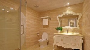 A bathroom with a glass shower enclosure, a white toilet, a vanity with a mirror, and a towel rack. - Hongxing Boutique Hotel (Shantou)