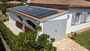 A house with a solar panel roof, a satellite dish, and a stone pathway. - Las flores 3A, Begur, Costa Brava (Begur)