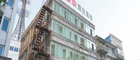 A multi-story building with a prominent red sign at the top.