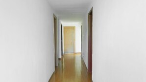 A narrow hallway with wooden flooring and white walls. - OYO Quzhou Zhenxing Hotel (Quzhou)