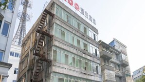 A building with a sign reading "OYO" and a staircase leading to an upper level. - OYO Quzhou Zhenxing Hotel (Quzhou)