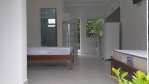 Ein modernes Schlafzimmer mit Bett, Schreibtisch und Fernseher.