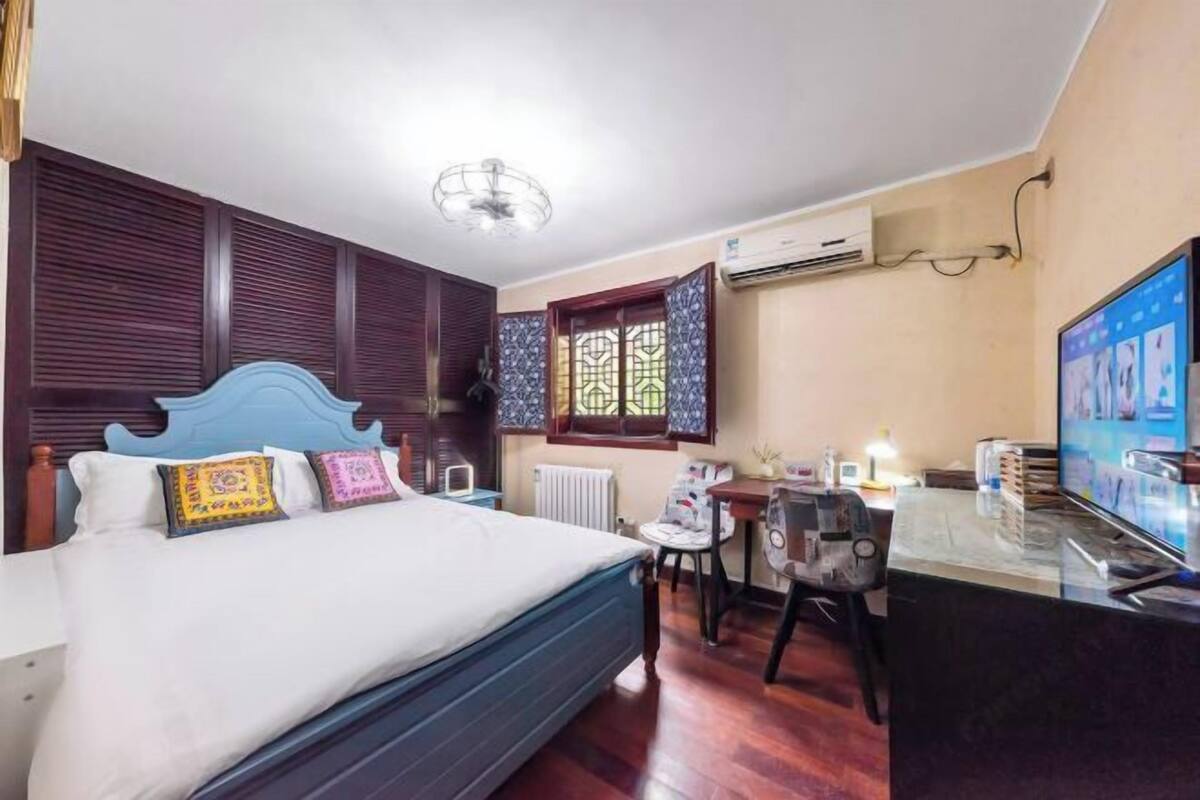 Une chambre d’hôtel avec un lit, un bureau, une chaise et un téléviseur.