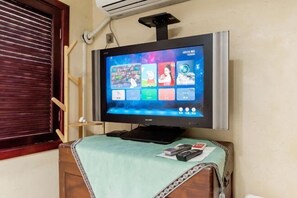 Un téléviseur fixé au mur, avec un meuble en bois placé en dessous.
