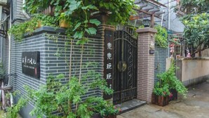 A brick building with a black gate and a sign with Chinese characters. - Shanghai Shikumen Culture Homestay (Shanghai)