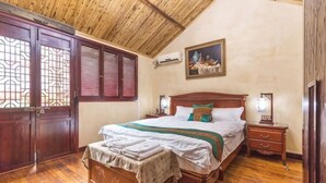 A bedroom with a wooden ceiling, a bed with a wooden headboard, a nightstand, a wall-mounted air conditioner, and a window with wooden shutters. - Shanghai Shikumen Culture Homestay (Shanghai)
