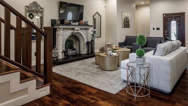 Un salon avec une cheminée, un canapé, une table basse et un téléviseur.