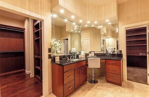 Une salle de bain spacieuse avec un grand meuble-lavabo, un miroir et un dressing.