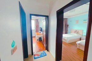 Habitación de hotel con cama, escritorio y vista al pasillo.