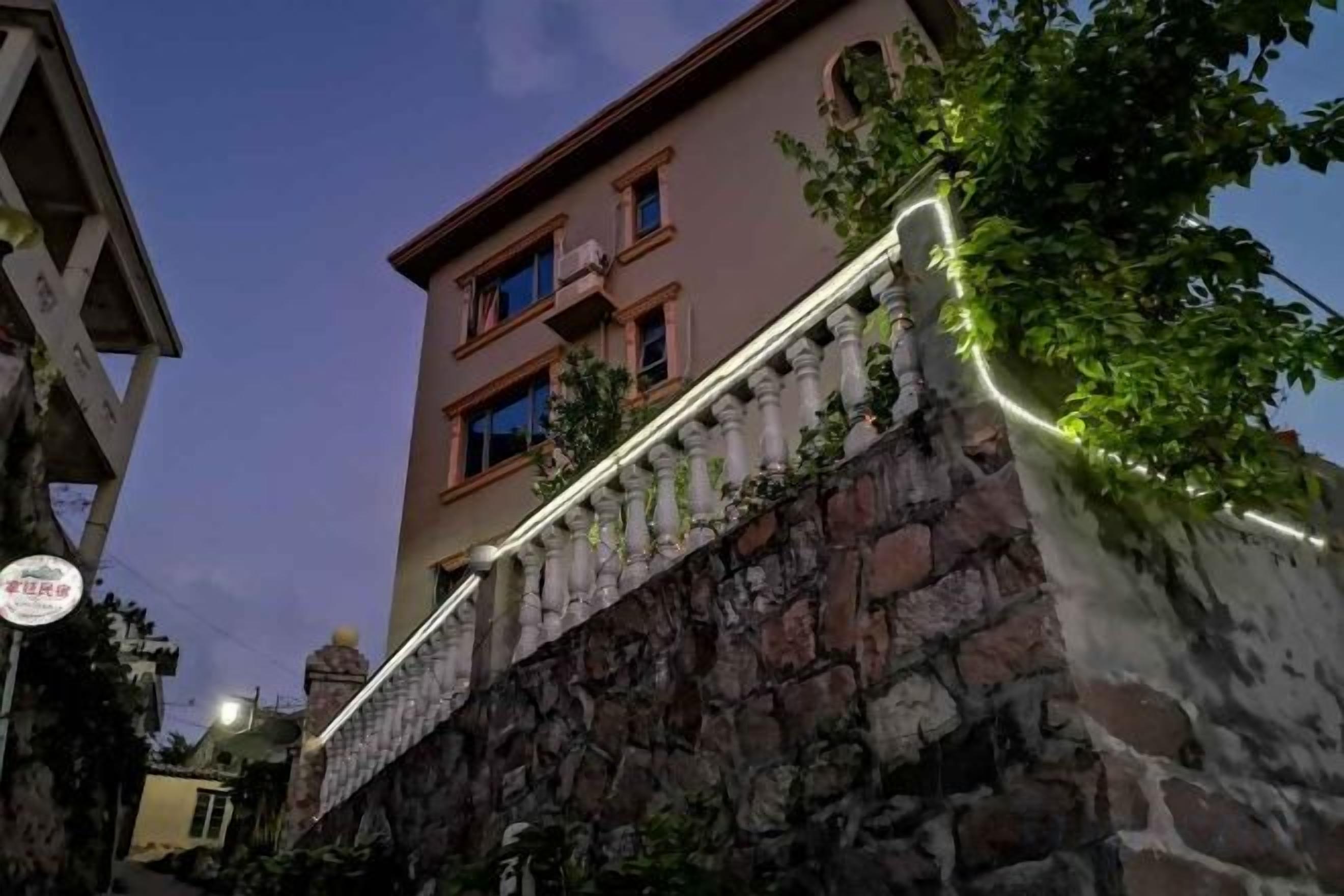 A building with a stone facade and a balcony with a railing.
