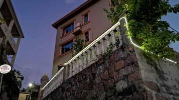 A building with a stone facade and a balcony with a railing.