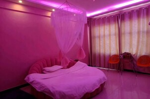 Una habitación con cama, dosel, cortinas y dos sillas.