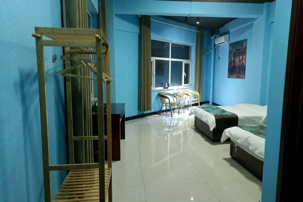 A room with a bed, a chair, a desk, and a window.