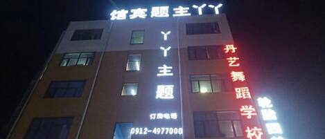 A building with illuminated signage indicating 'Y' and 'Y' in large letters, and a phone number '0912-4977000' below.