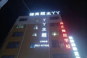En bygning med oplyste skilte, der viser 'Yanyue' og 'Dan Art School'.