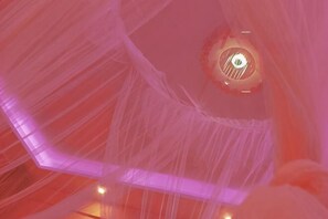 Un soffitto con motivo geometrico e un lampadario circolare.