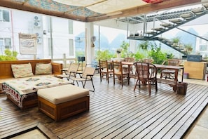 A wooden deck with seating and a staircase leading to an upper level. - Countryside Villa Yulong Hepan Boutique Farmhouse (Yangshuo)