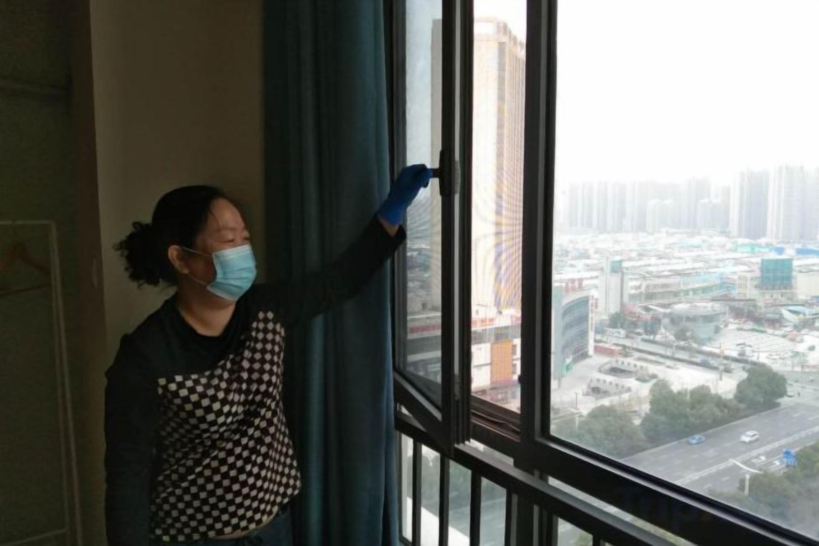 A person cleaning a window with a view of a cityscape.