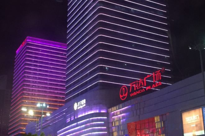 Een modern gebouw met verlichte reclameborden en een opvallend logo.