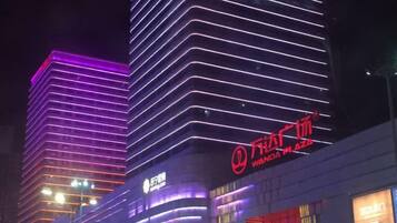 Een modern gebouw met verlichte reclameborden en een opvallend logo.