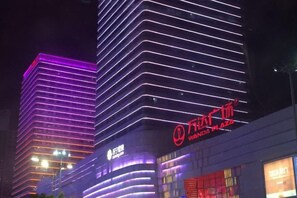 A modern building with illuminated signage and a prominent logo. - Yiyi Sentiment Apartment Hotel (Bengbu)