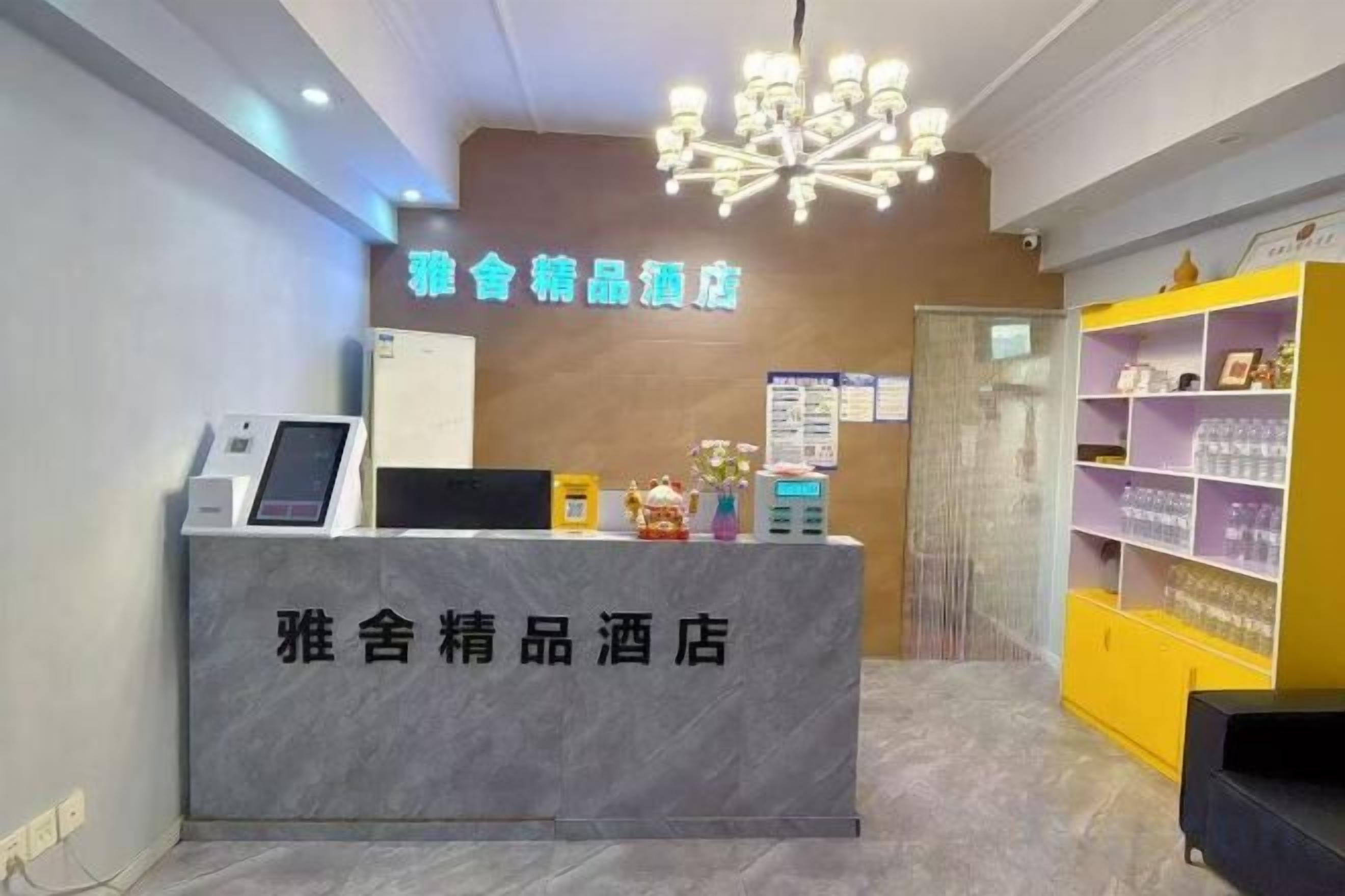A hotel reception area with a marble counter, a digital kiosk, and a reception desk.