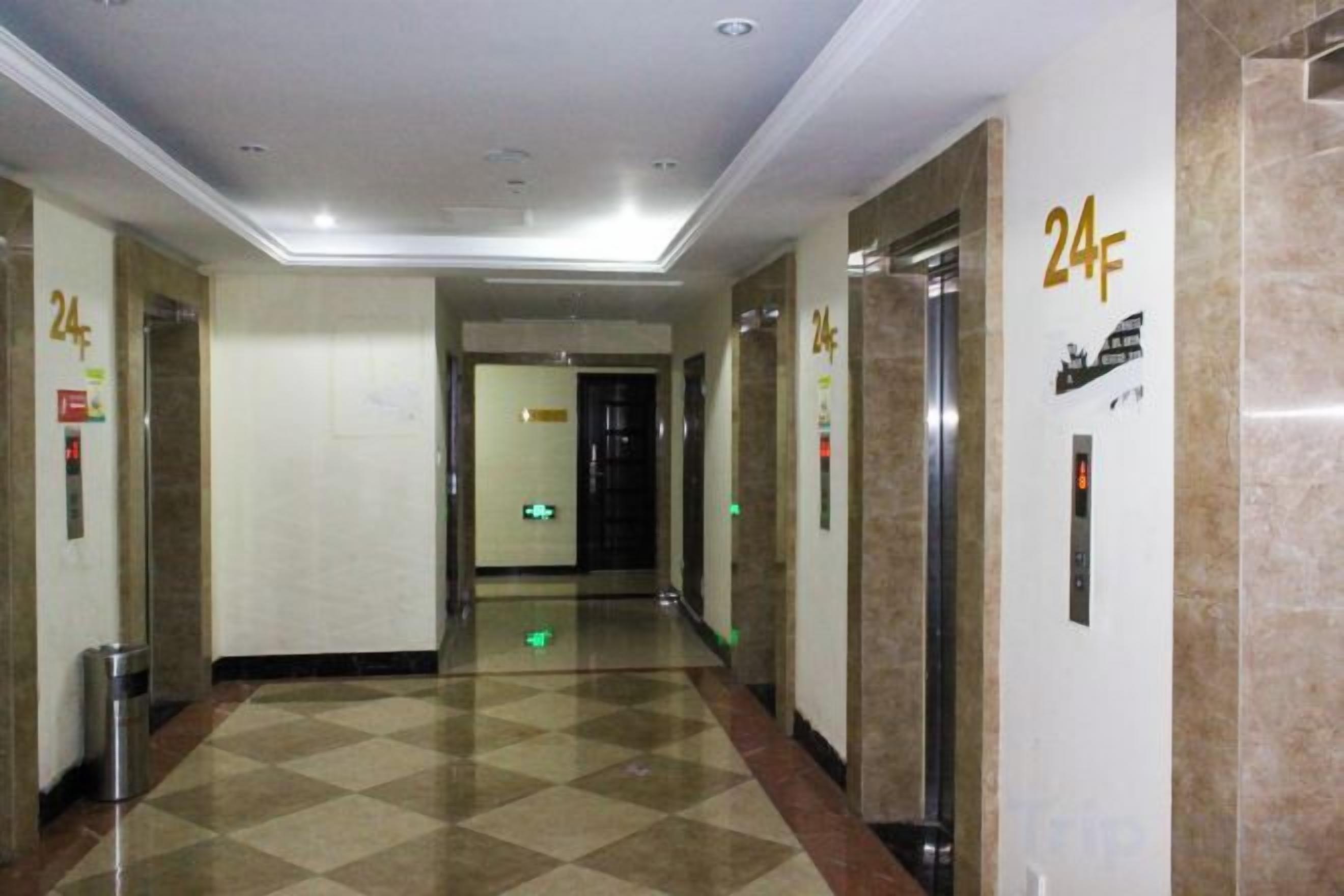 A hallway with a checkered floor, two elevators, and a door with a 24F sign.