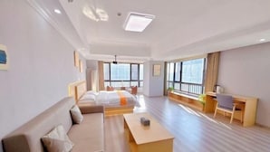 Une chambre d’hôtel avec un lit, un canapé, un bureau et une grande fenêtre.