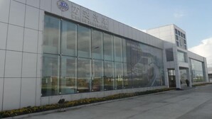 A modern building with large glass windows and a sign that reads "Driving Pie". - Wanda Motel (Bei'an)