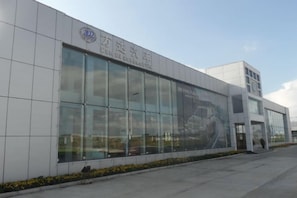 A modern building with large windows and a sign that reads 'Driving Innovation.' - Wanda Motel (Bei'an)