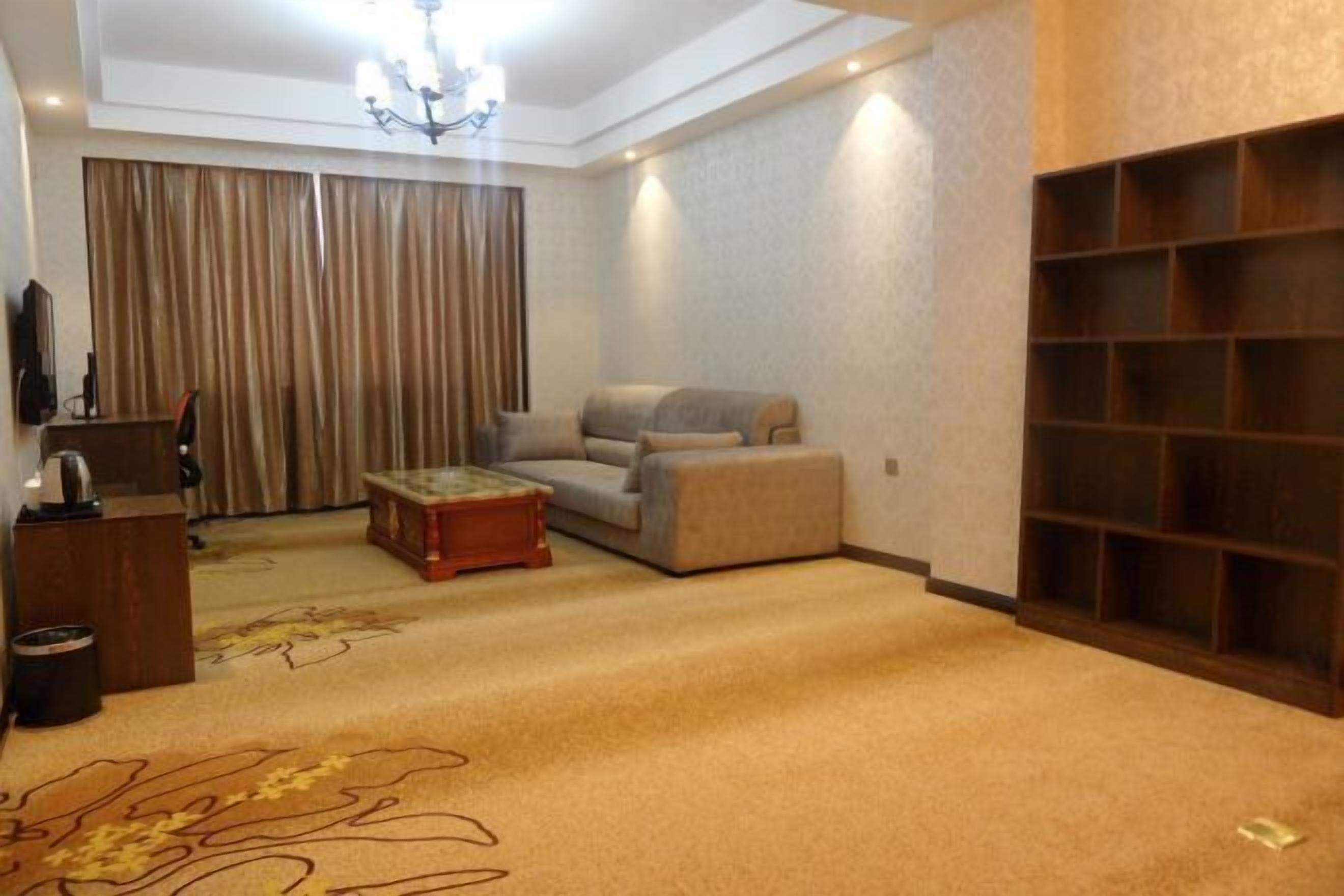 Ein geräumiges Wohnzimmer mit einer Couch, einem Couchtisch und einem Bücherregal.