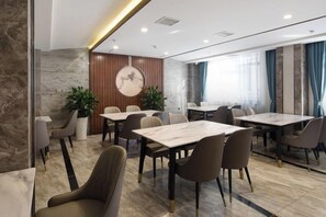 A modern conference room with marble flooring, wooden accents, and a large round table. - Colorful Xiangxi Inn (Zhangjiajie)