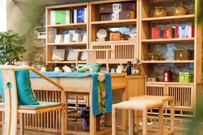 A bookstore with wooden shelves and chairs. - Colorful Xiangxi Inn (Zhangjiajie)