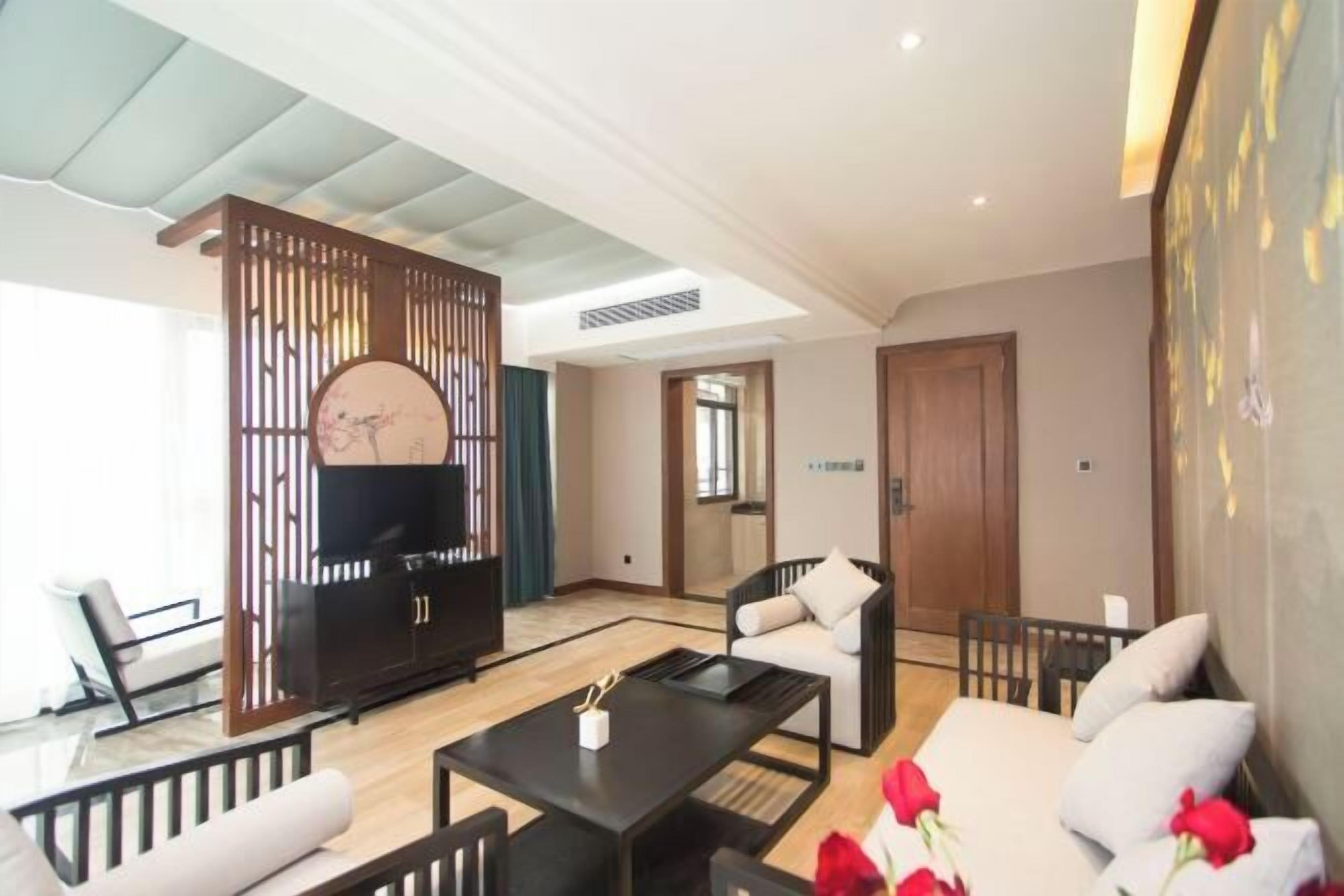 Een moderne woonkamer met een bank, fauteuils, een salontafel en een televisie.