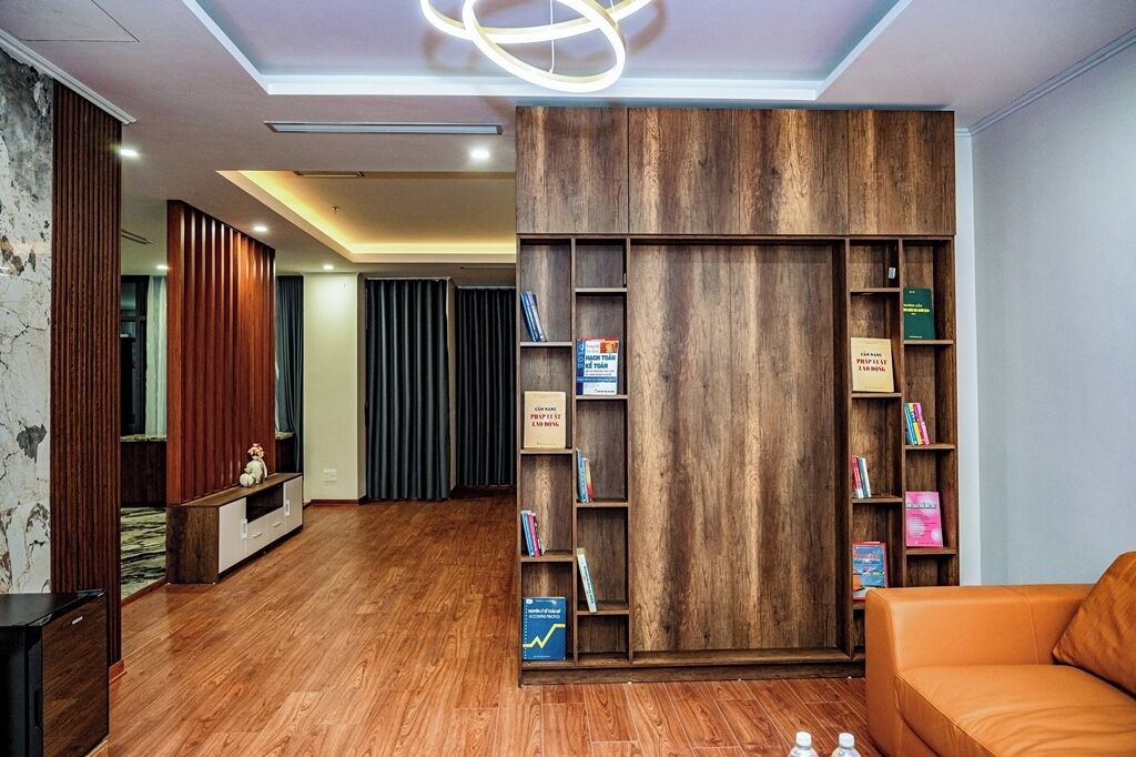 Un salon moderne avec une bibliothèque en bois, un canapé et un téléviseur.
