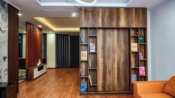 Un salon moderne avec une bibliothèque en bois, un canapé et un téléviseur.